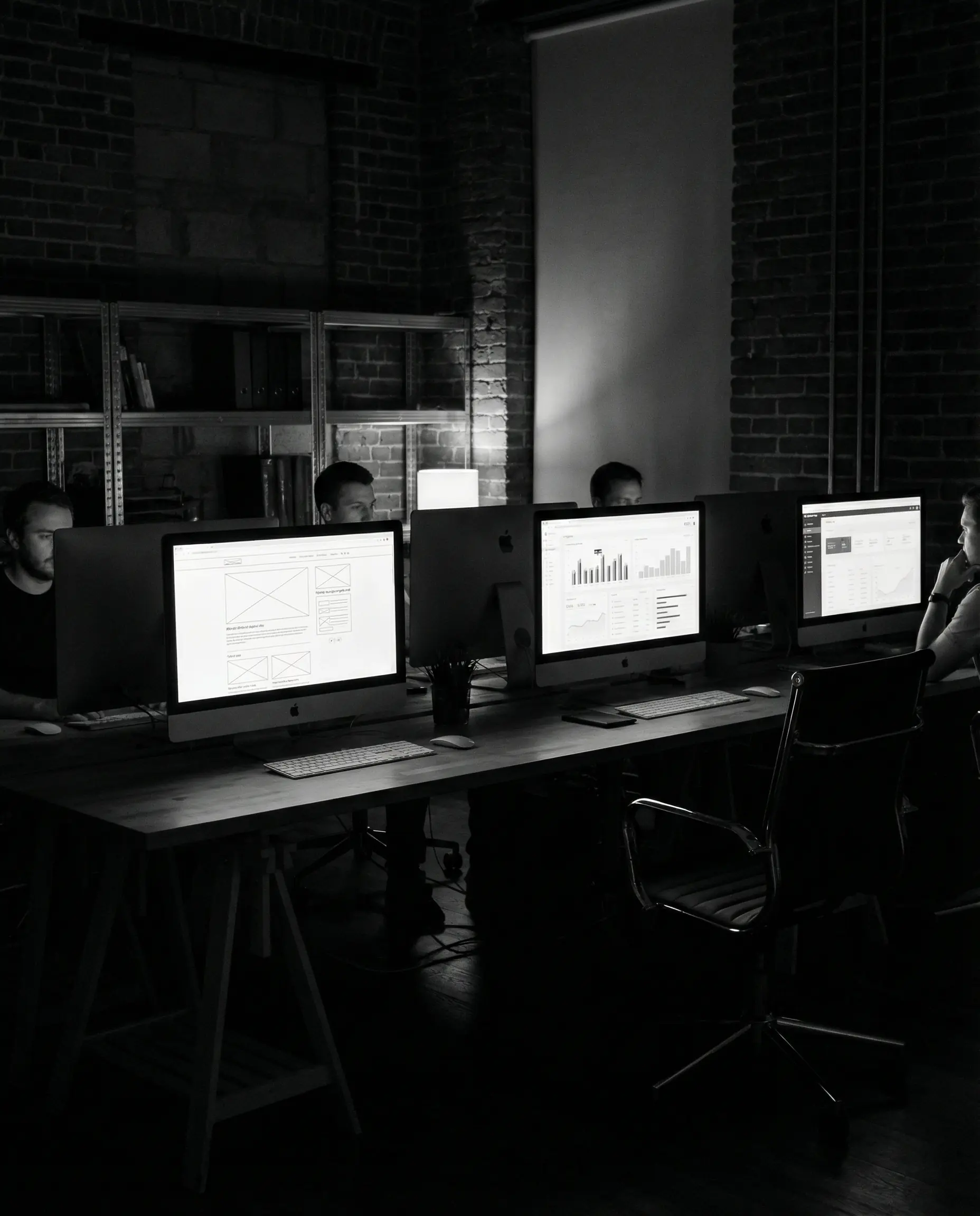Team working at monitors displaying wireframes and analytics